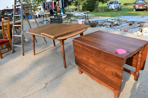 Furniture is placed outdoors at an estate sale. it is priced.